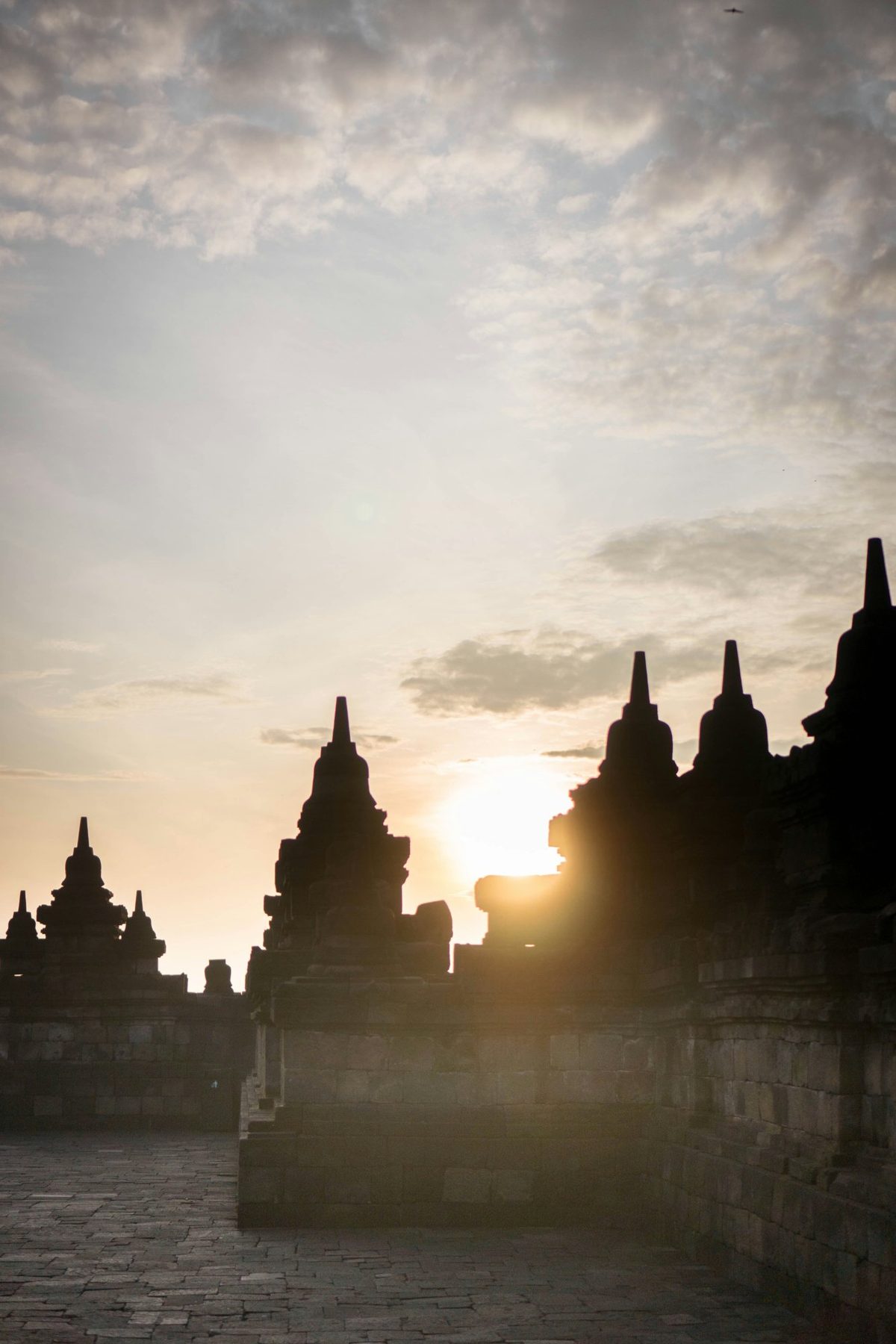 Borobudur Temple at sunrise — the world's largest Buddhist monument, 504 Buddha statues arranged across 9 stone terraces in Central Java, Indonesia. UNESCO World Heritage Site (1991, inscription 592).